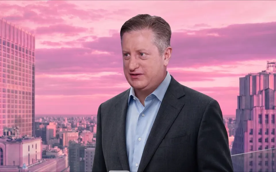 Steve Eisman holding a phone on a rooftop above a city skyline